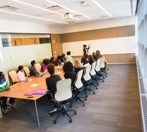 A diverse group actively collaborating in a bright, modern conference room setting.